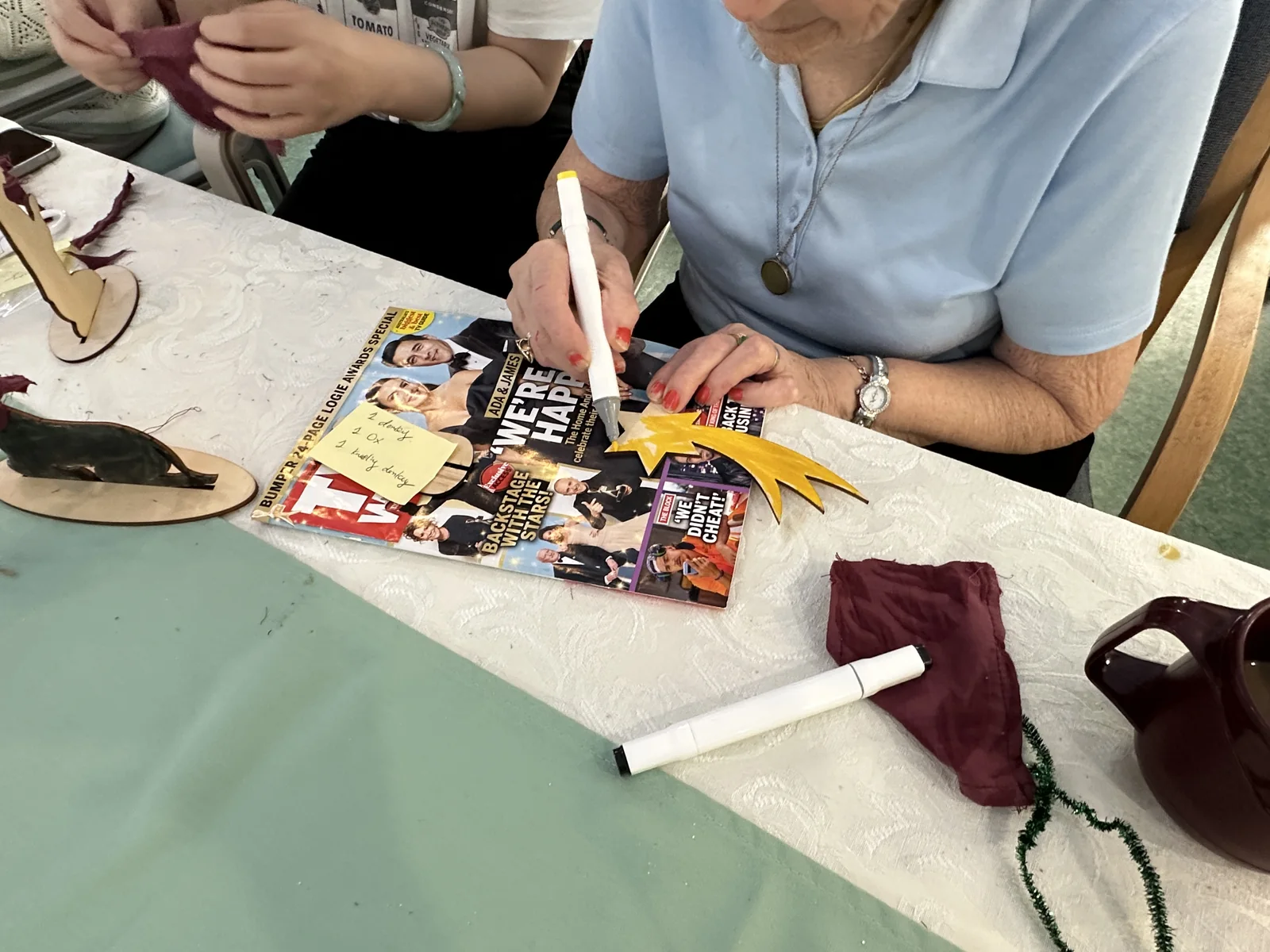 A resident colouring a wooden star yellow with a marker