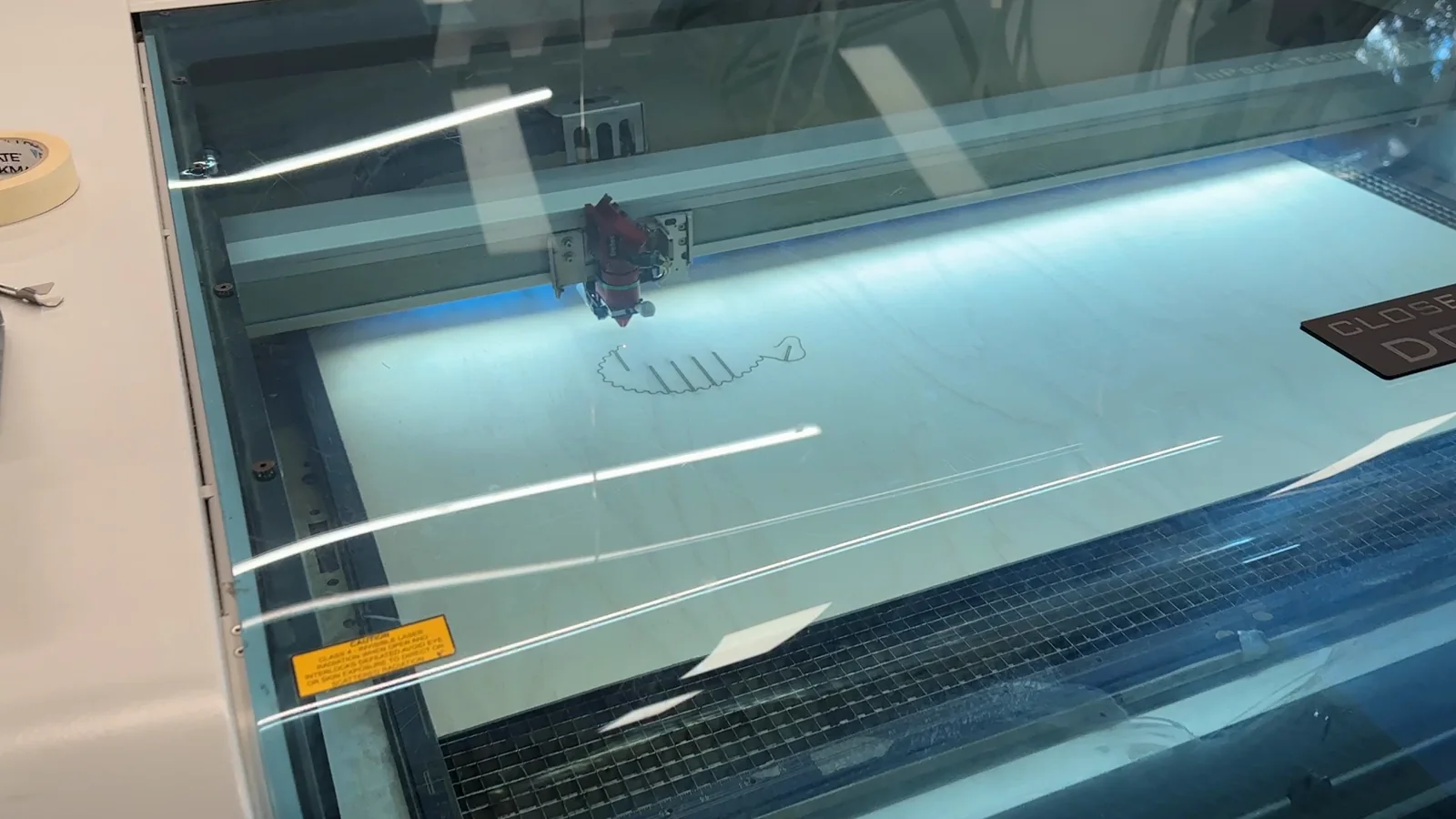 A laser cutter producing wooden sheep components