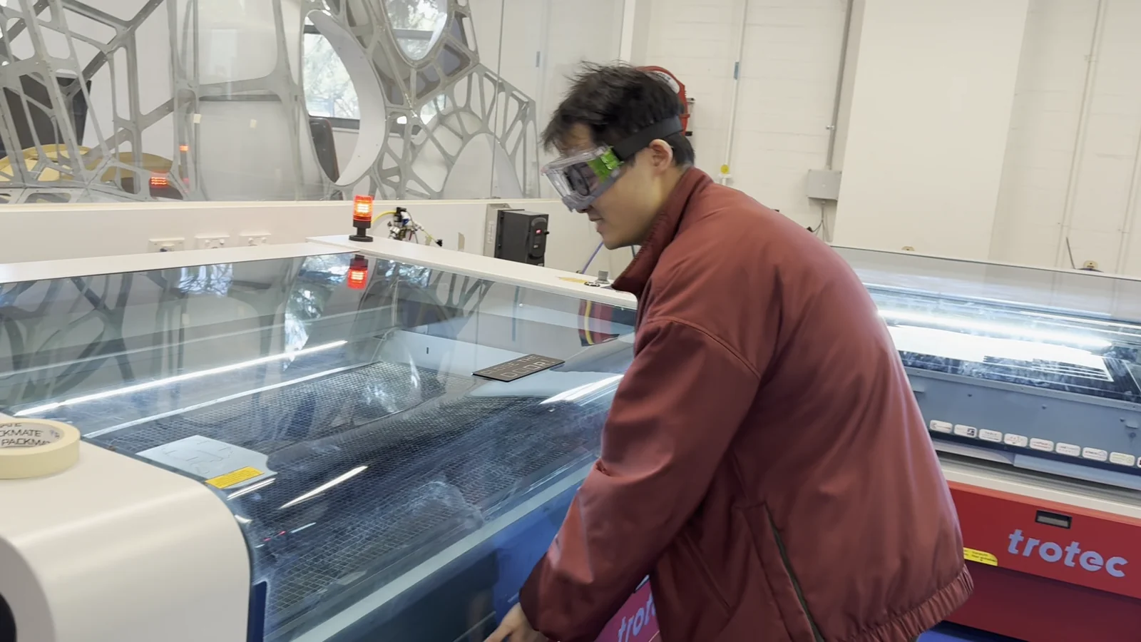 Xingting Wu working at a laser cutter in Swinburne ProtoLAB